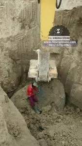 penggalian bahan baku batu andesit dengan excavator