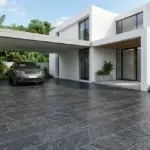 Desain lantai carport batu andesit abu gelap pola horizontal di rumah minimalis modern tropis